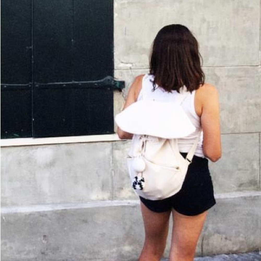 Off white canvas backpack with cute pop-pom embellished string closure